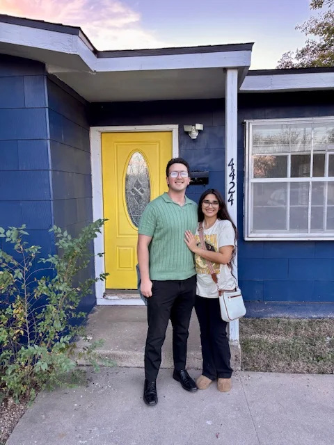 A couple celebrating together in front of their new home