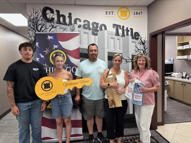 Home buyers and their closing team celebrating together after signing