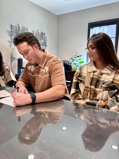 A home-buying couple signing their closing documents